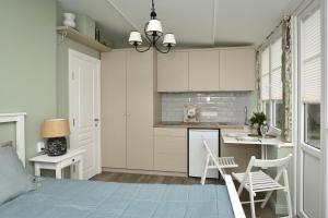 a bedroom with a bed and a kitchen at Anna Green House in Palanga