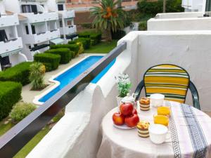 a table with fruit and drinks on a balcony with a pool at Apartment Coto Gamo Holiday Escape by Interhome in Pals +20 photos