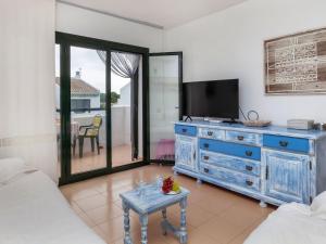 - un salon avec une télévision et une commode bleue dans l'établissement Apartment El Coto G by Interhome, à Pals