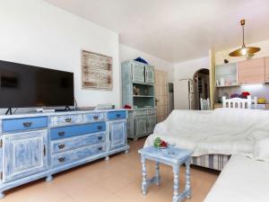a living room with a blue dresser with a tv at Apartment Coto Gamo Holiday Escape by Interhome in Pals