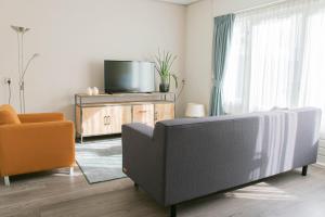 a living room with a couch and a tv at Hotel Lemmer in Lemmer
