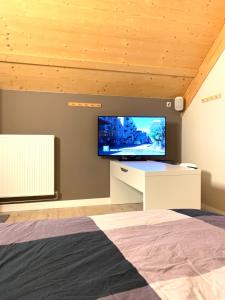 1 dormitorio con TV de pantalla plana en la pared en Ecolodge Zen Otra Cosa en Mouscron