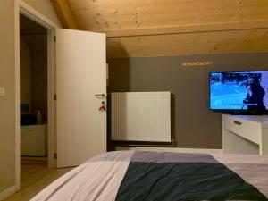 a bedroom with a bed with a tv on the wall at Ecolodge Zen Otra Cosa in Mouscron