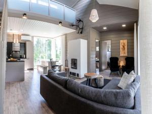 a living room with a large couch and a kitchen at Holiday Home Loma-saaga 3 by Interhome in Syöte