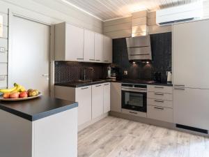 a kitchen with white cabinets and a plate of fruit at Holiday Home Loma-saaga 3 by Interhome in Syöte