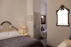 a bedroom with a bed and a window and a mirror at Hôtel Amphithéâtre in Arles