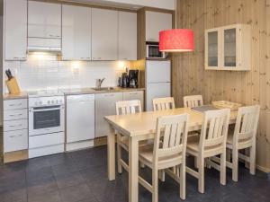 eine Küche mit einem Holztisch und weißen Geräten in der Unterkunft Holiday Home Rukatonttu d 12 by Interhome in Ruka