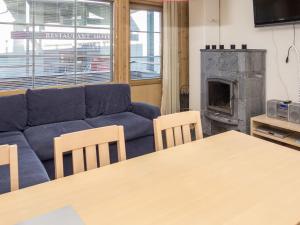 ein Wohnzimmer mit einer blauen Couch und einem Kamin in der Unterkunft Holiday Home Rukatonttu d 12 by Interhome in Ruka