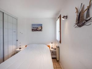 een witte slaapkamer met een bed en een raam bij Apartment Les Soleils Rouges-14 by Interhome in Vaux-sur-Mer