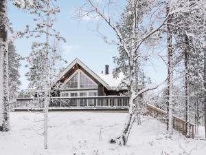 a house with a deck in the snow at Holiday Home Peurakumpu by Interhome in Ivalo