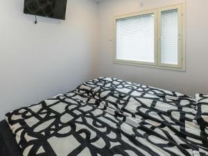 a bedroom with a black and white bed with a window at Holiday Home Hiekkalahti by Interhome in Sastamala +9 photos