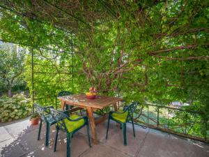 a wooden table with four chairs under a tree at Apartment Rita by Interhome in Dražice