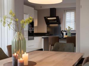 a kitchen with a wooden table with a vase with candles at Holiday Home Ganuenta-1 by Interhome in Colijnsplaat