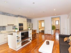 an open kitchen and living room with white cabinets at Apartment Centro- Passeig de Gracia - Casa Batllo by Interhome in Barcelona