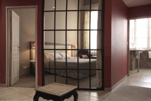 a room with a bedroom with a bed and a mirror at Hôtel Amphithéâtre in Arles
