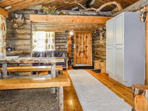 Cabaña de madera con sala de estar con sofá y mesa en Holiday Home Kelokota by Interhome en Salla