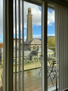 einen Blick aus einem Fenster eines Gebäudes mit einem Uhrturm in der Unterkunft Blissful One Bed Near The River in Kew Bridge