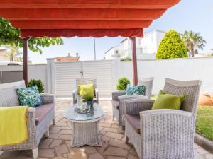 a patio with wicker chairs and a table at Holiday Home Estrella by Interhome in Riumar