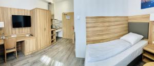 Zimmer mit einem Bett, einem Schreibtisch und einem TV in der Unterkunft Garni-Hotel zur Krone in Schwieberdingen