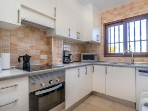 a kitchen with white cabinets and a window at Apartment Bellavista I by Interhome in Orihuela +11 photos