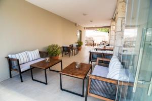 Lagaria Luxury Rooms & Apartments في أسبروبالتا: فناء به طاولات وأرائك وفناء به طاولة
