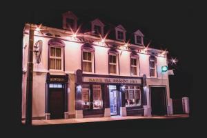 a large building with lights on it at night at Barr Na Sraide Inn in Dingle