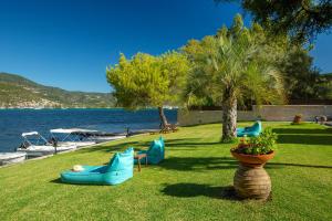 a park with chairs and boats on the water at Cleopatra Beach in Yenion