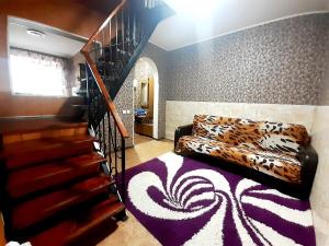 a living room with a leopard print couch and stairs at Шевченко 2 in Kropyvnytskyi