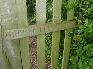 ein Holzzaun mit einem Schild, das Differenzialwegsuche liest in der Unterkunft The Coach House in Milford