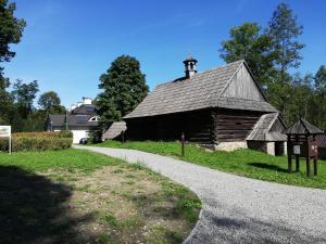 un antiguo granero al lado de una carretera en Apartament nad Gorczańskim Strumieniem, en Koninki