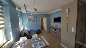 a living room with blue walls and a table at Apartament New Gdynia in Gdynia