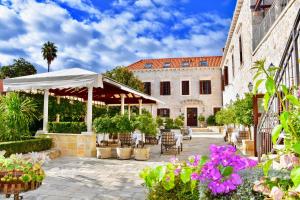 een patio met een witte parasol en bloemen bij Boutique Hotel Kazbek in Dubrovnik