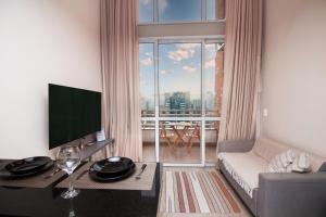 un soggiorno con divano e una grande finestra di Multihouse - Moderno Duplex Berrini - WTC - Brooklin a San Paolo