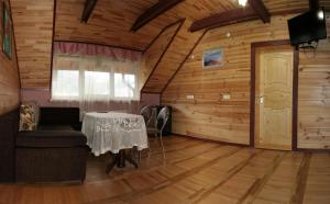 uma sala de jantar com uma mesa numa sala de madeira em Гніздо Беркута em Tukhlya