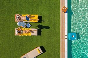 un groupe de personnes debout à côté d'une piscine dans l'établissement Villa Artemida Vravrona, à Vravrona