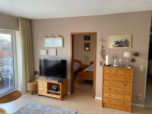 ein Wohnzimmer mit einem TV und ein Schlafzimmer in der Unterkunft Ferienwohnung Witthöhn 8 in Cuxhaven