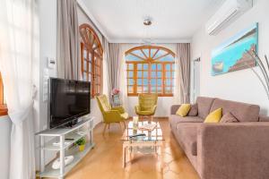 a living room with a couch and a tv at Villa Artemida Vravrona in Vravrona