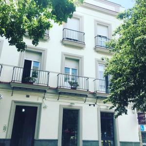 ein weißes Gebäude mit Balkonen an der Seite in der Unterkunft Eva Recommends Porvenir Apartment in Jerez de la Frontera