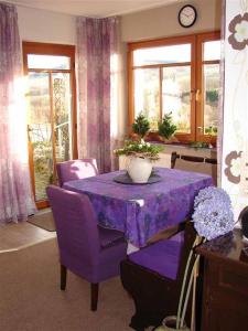mesa púrpura con sillas púrpuras y mantel púrpura en Ferienwohnung Stirnbergblick, en Ehrenberg