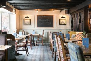 ein Restaurant mit Tischen und Stühlen und einer Tafel an der Wand in der Unterkunft The Angel & Blue Pig in Lymington