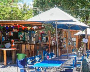 Un mercado al aire libre con sillas azules y una sombrilla. en Tilcara Mistica Hostel, en Tilcara