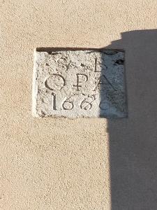 a stone sign on the side of a building at Central Lovely House in Montepulciano