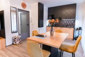 a kitchen and dining room with a wooden table and chairs at Bella Mura Golden Apartment in Moravske Toplice +37 photos