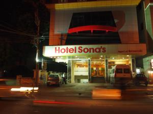 un cartello di un hotel di fronte a un edificio di notte di Hotel Sonas a Tiruchchirāppalli