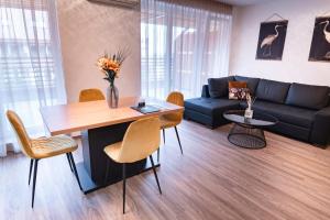 a living room with a table and a couch at Bella Mura Golden Apartment in Moravske Toplice