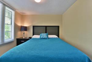 a bedroom with a blue bed with a blue pillow on it at Siesta Key Beach - Bari 665 #2 in Siesta Key