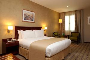 a hotel room with a large bed and a desk at Holiday Inn Olaya, an IHG Hotel in Riyadh