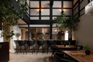 HOTEL 101 KANAZAWA في كانازاوا: مطعم فيه بار فيه كراسي وطاولات