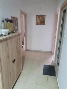 a hallway with a white tile floor and a cabinet at Rooms Lagat in Troyan