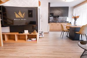 a living room with a table and a kitchen at Bella Mura Golden Apartment in Moravske-Toplice